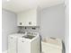 A well-lit laundry area complete with washer, dryer, utility sink and built-in cabinets at 1364 Westport Ln # 1403, Sarasota, FL 34232