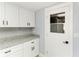Bright, updated pantry area with white cabinets, granite counter and glass door at 1364 Westport Ln # 1403, Sarasota, FL 34232