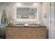 Bathroom vanity featuring double sinks and a decorative illuminated mirror at 14041 Bellagio Way # 218, Osprey, FL 34229
