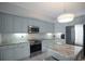 A stylish kitchen features stainless steel appliances, marble countertops, and light blue cabinetry at 14041 Bellagio Way # 218, Osprey, FL 34229