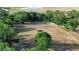 Aerial view showing expansive yard, mature trees and pond in the distance at 15308 Fruitville Rd, Sarasota, FL 34240