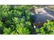 Aerial view highlighting the home's roof and proximity to lush, green trees, offering a private setting at 15308 Fruitville Rd, Sarasota, FL 34240