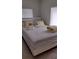 A neutral-colored bedroom features a bed with yellow accent pillows and tile floors at 15308 Fruitville Rd, Sarasota, FL 34240