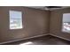 Bright bedroom with wood-look floors, neutral walls, and natural light from two windows at 15308 Fruitville Rd, Sarasota, FL 34240