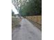 Long gravel driveway with a wooden fence and outbuildings visible in the distance at 15308 Fruitville Rd, Sarasota, FL 34240