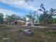 Spacious property featuring an RV, red car, and outbuildings under a sunny sky at 15308 Fruitville Rd, Sarasota, FL 34240