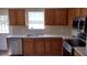 Functional kitchen with stainless steel appliances, wood cabinets, and a double sink under a window at 15308 Fruitville Rd, Sarasota, FL 34240