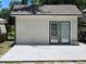Exterior view of light colored shed with double doors and concrete pad at 15308 Fruitville Rd, Sarasota, FL 34240
