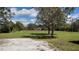 Large grassy yard with scattered trees under a blue sky, perfect for outdoor activities at 15308 Fruitville Rd, Sarasota, FL 34240