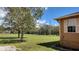 Expansive grassy yard with mature trees bordering the property, offering privacy and a natural setting at 15308 Fruitville Rd, Sarasota, FL 34240