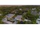 Aerial view of property showcasing the lush landscaping, sparkling pool, and modern architecture nestled among mature trees at 1559 Bay Rd, Sarasota, FL 34239
