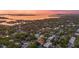 Stunning aerial view of a neighborhood, showcasing lush trees, a bay, and beautiful houses at sunset at 1559 Bay Rd, Sarasota, FL 34239