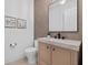Powder room features a modern vanity, neutral textured wallpaper, toilet, and decor at 1559 Bay Rd, Sarasota, FL 34239