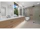 Bright modern bathroom with double vanity, sleek fixtures, walk-in shower and luxurious soaking tub at 1559 Bay Rd, Sarasota, FL 34239