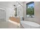 Spa-like bathroom with a modern soaking tub, glass-enclosed shower, double vanity, and natural light at 1559 Bay Rd, Sarasota, FL 34239