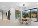 Dining area features a modern light fixture, round table with seating for six, and large windows overlooking the backyard at 1559 Bay Rd, Sarasota, FL 34239
