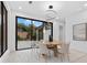 Dining area with a modern light fixture, round table with seating for six, and view of the landscaped backyard at 1559 Bay Rd, Sarasota, FL 34239