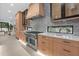 Close-up of the kitchen featuring custom cabinets, stainless steel oven, and mosaic backsplash at 1559 Bay Rd, Sarasota, FL 34239