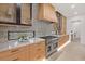Close-up of a modern kitchen, highlighting the range and unique backsplash design at 1559 Bay Rd, Sarasota, FL 34239