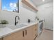 Bright laundry room with modern appliances, white countertops, and convenient storage at 1559 Bay Rd, Sarasota, FL 34239
