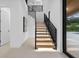 Elegant staircase featuring modern black railings, wood treads and recessed lighting for a bright and open feel at 1559 Bay Rd, Sarasota, FL 34239