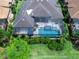 Aerial view of a private home featuring a screened pool, spa, manicured yard, and outdoor entertaining spaces at 16614 Berwick Ter, Lakewood Ranch, FL 34202