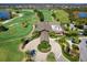 Stunning aerial view of golf course and clubhouse featuring lush greenery, manicured grounds, and scenic views at 16614 Berwick Ter, Lakewood Ranch, FL 34202
