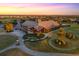 Spectacular aerial view of golf course clubhouse at sunset, showcasing the picturesque landscaping and vibrant colors at 16614 Berwick Ter, Lakewood Ranch, FL 34202