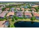 Community aerial view showcasing private homes with pools, surrounded by lush landscaping, with a pond in the foreground at 16614 Berwick Ter, Lakewood Ranch, FL 34202