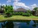 Scenic backyard view featuring a tranquil pond, lush landscaping, and a private residence with a screened enclosure at 16614 Berwick Ter, Lakewood Ranch, FL 34202