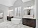 Stunning main bathroom featuring dual vanities, soaking tub, and tiled floors at 16614 Berwick Ter, Lakewood Ranch, FL 34202