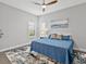Bedroom featuring a blue bed, decorative rug, and two shuttered windows with natural light at 16614 Berwick Ter, Lakewood Ranch, FL 34202