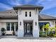 Stately home with white columns, a blue-framed glass door, and well-manicured landscaping at 16614 Berwick Ter, Lakewood Ranch, FL 34202