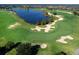 Scenic aerial view of the golf course with lush green fairways, sand traps, and a tranquil lake at 16614 Berwick Ter, Lakewood Ranch, FL 34202