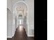 Hallway with wood floors and arched doorways, leading to a white-framed front door at 16614 Berwick Ter, Lakewood Ranch, FL 34202