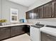 Laundry room showcases dark cabinets, a granite countertop, and a modern washer and dryer at 16614 Berwick Ter, Lakewood Ranch, FL 34202