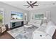 Cozy living room offers stylish seating, a ceiling fan, and a large TV for entertainment at 16614 Berwick Ter, Lakewood Ranch, FL 34202