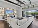 Open-concept living room features beamed ceilings, a stone fireplace, and sliding glass doors to the outdoor living area at 16614 Berwick Ter, Lakewood Ranch, FL 34202