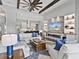 Elegant living room showcasing beamed ceilings, a stone fireplace, and an open layout with a view to the kitchen at 16614 Berwick Ter, Lakewood Ranch, FL 34202