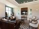 Comfortable living room with a leather sofa, stylish rug, and large-screen TV for relaxation at 16614 Berwick Ter, Lakewood Ranch, FL 34202