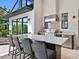 Outdoor kitchen featuring a granite countertop, stainless steel appliances, and a bar area at 16614 Berwick Ter, Lakewood Ranch, FL 34202