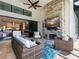 Inviting outdoor living area with stone fireplace, TV, and comfortable seating for relaxing and entertaining at 16614 Berwick Ter, Lakewood Ranch, FL 34202