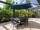 Charming outdoor dining area with a shaded table and chairs, surrounded by lush greenery and a screened enclosure at 16614 Berwick Ter, Lakewood Ranch, FL 34202