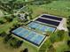 Aerial view of community pickleball courts and parking surrounded by lush landscaping and golf course at 16614 Berwick Ter, Lakewood Ranch, FL 34202
