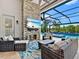 Outdoor living area with stone fireplace, comfortable seating, and a view of the pool at 16614 Berwick Ter, Lakewood Ranch, FL 34202