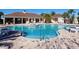 Inviting swimming pool area with lounge chairs, tables, and umbrellas, perfect for relaxation at 16614 Berwick Ter, Lakewood Ranch, FL 34202