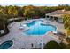 Aerial view of a uniquely shaped community pool with ample seating and a nearby jacuzzi at 16614 Berwick Ter, Lakewood Ranch, FL 34202
