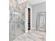 Elegant bathroom features a glass enclosed shower, marble tile, and access to walk-in closet at 16614 Berwick Ter, Lakewood Ranch, FL 34202
