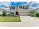 Well-manicured lawn and landscaping accents this two-story home with a two-car garage and concrete driveway at 17124 Harvest Moon Way, Lakewood Ranch, FL 34211