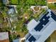 An aerial view of a landscaped backyard, patio area, and solar panels on the roof at 1722 Hazelwood St, Sarasota, FL 34231